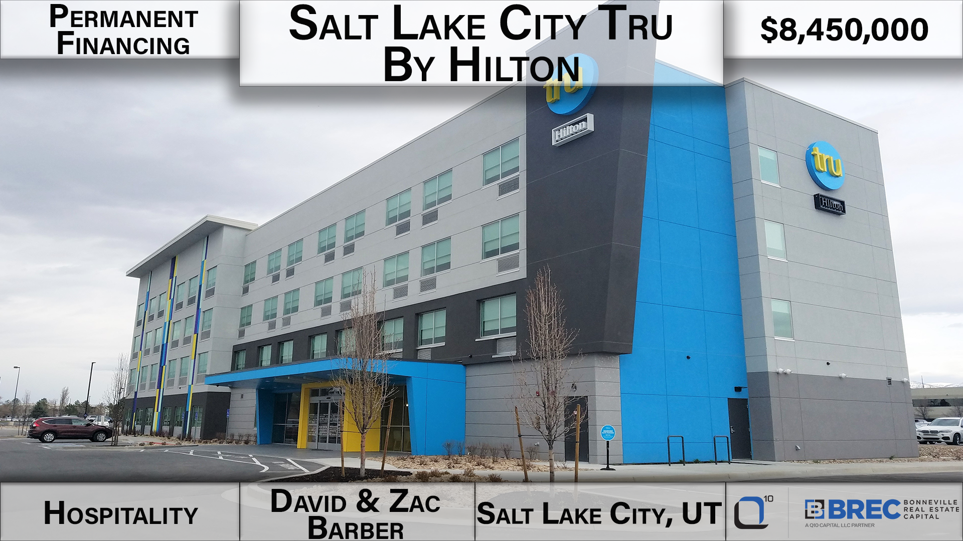 diagonal view of four-story hotel with a bright blue exterior accent wall and awning